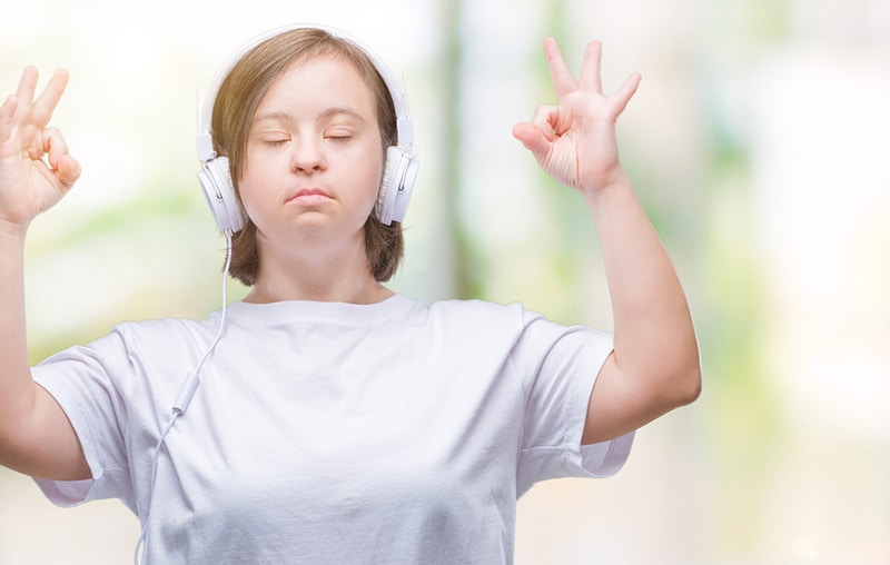 Calm woman meditating with headphones on