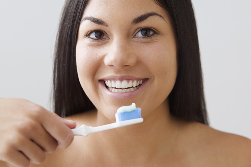 young woman brushing her teeth